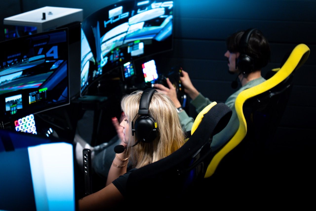 Two drivers in headsets racing each other on side-by-side rigs